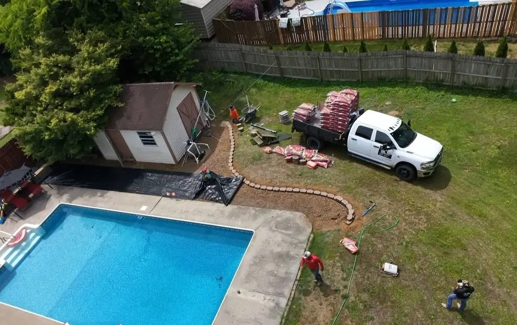 Aerial view of paver bed edging going in around a pool in Cleveland, Tennessee