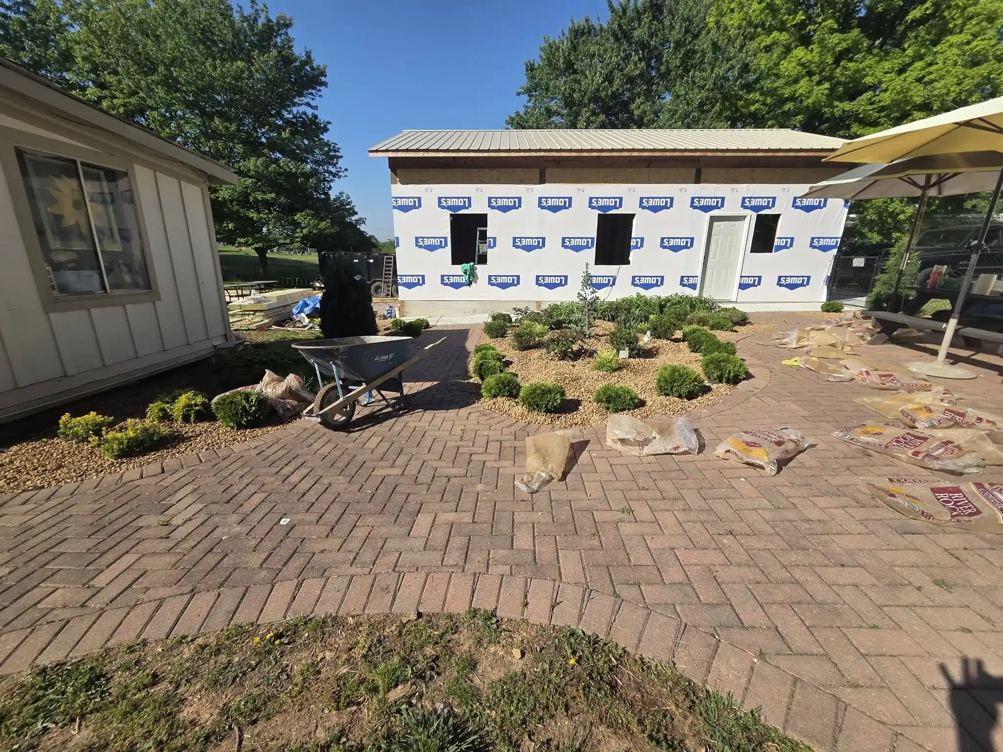 Brick paver courtyard laid along a building with new planting beds in Cleveland, Tennessee