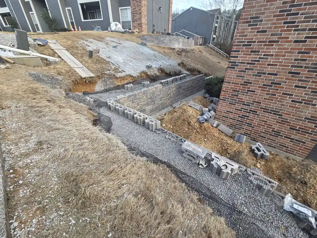 Aerial view of a block retaining wall running along a brick home near Cleveland, Tennessee