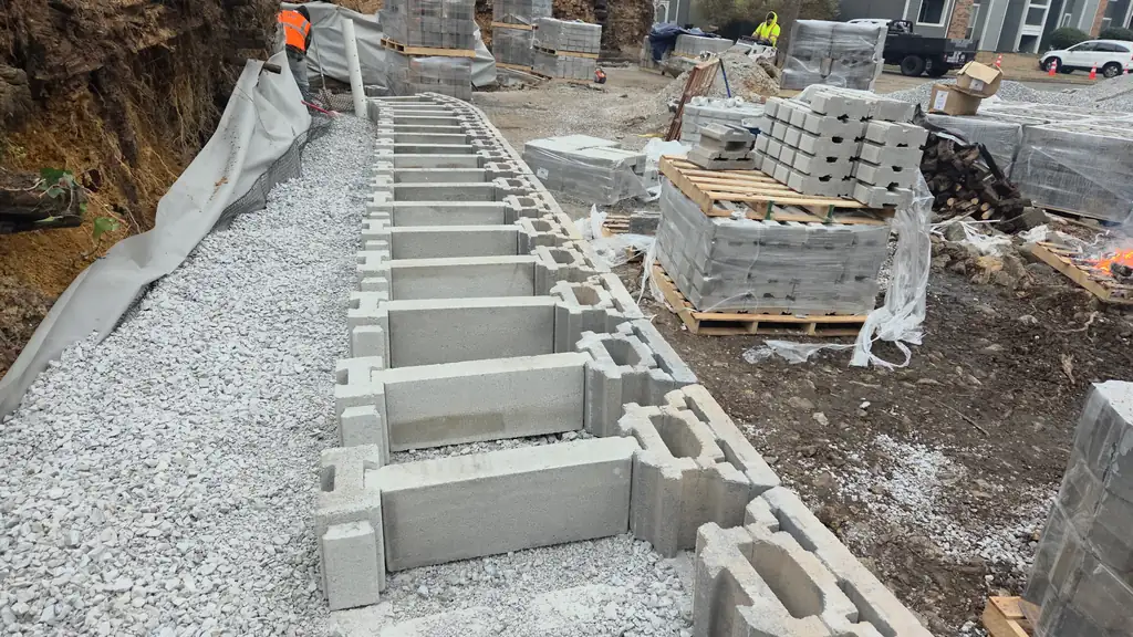 Retaining wall block course with compacted gravel backfill behind it in Cleveland, Tennessee
