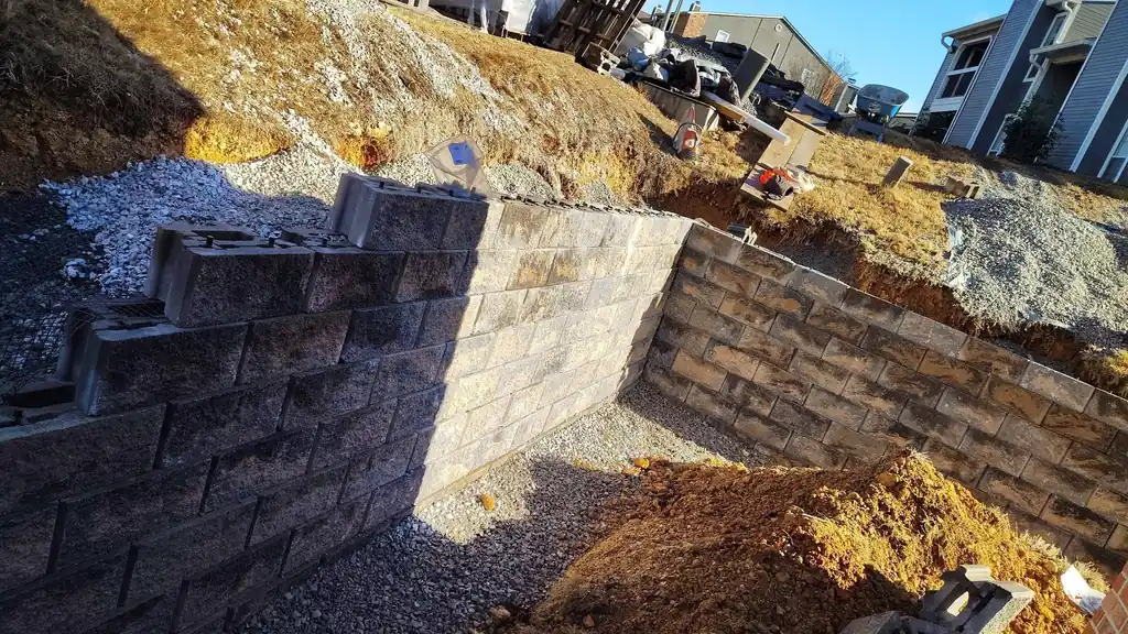 Tall dark block retaining wall cut into a hillside near Cleveland, Tennessee
